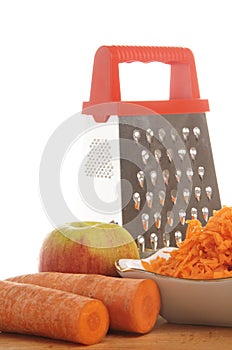 Grated carrots in a cup on a white background