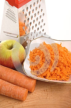 Grated carrots in a cup on a white background