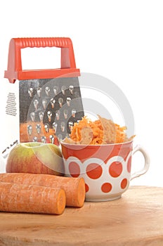 Grated carrots in a cup on a white background