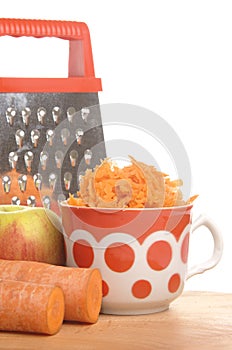 Grated carrots in a cup on a white background