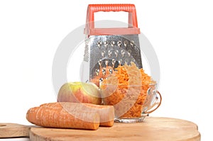 Grated carrots in a cup on a white background