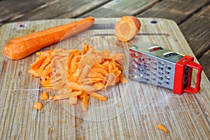 Grated carrots on a wooden cutting board. Unusual mystery and optical illusion
