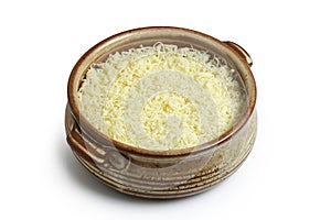 grated cheese in clay bowl