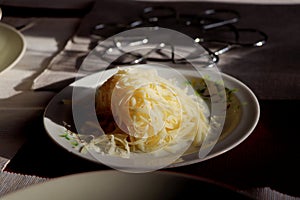 The grated cheese on colorful plate with shadows and sun rays