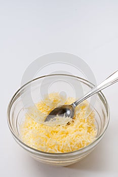 Grated cheese in a crystal bowl with spoon