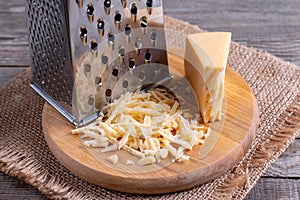 Grated cheese on a cutting board on a wooden table