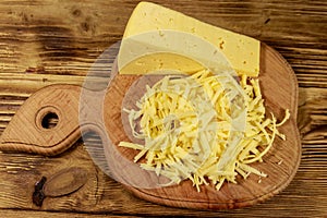 Grated cheese on cutting board on wooden table