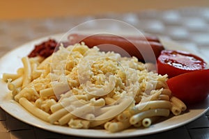 Grated pasta cheese with tomatoes and sausages on a plate