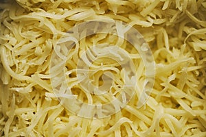Grated pizza cheese in close up texture shot