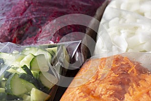 Grated and sliced vegetables, beetroot onion cucumber and carrot, in food bags