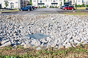 Grated storm drain inlet surrounded by rock for soil erosion control