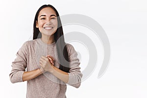 Grateful happy, smiling east-asian woman with long dark hair, clasp hands together pleased and delighted, thanking help