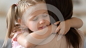 Grateful little child girl cute face embrace loving foster mother