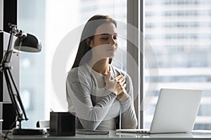 Grateful young woman feel thankful meditating at work