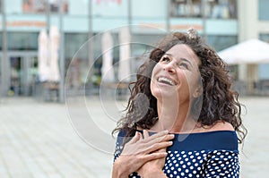 Grateful young woman with her hands to her heart photo