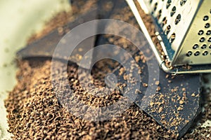 Grater and grated chocolate closeup