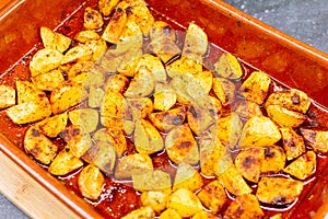 Gratin potatoes in red bowl preparing