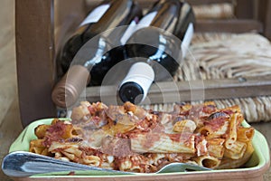 Gratineed pasta with red wine bottle