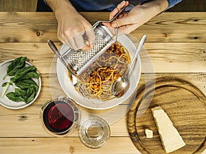 Grating cheese over spaghetti bolognese