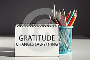 Gratitude changes everything - inscription on a notebook with colored pencils