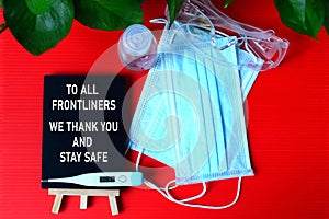 Gratitude to frontliners concept with red background of personal protective equipment