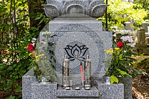 Grave in cemetery, Japan, with incense sticks photo