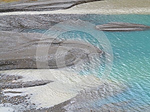 Glacial stream landscape detail, blue water at gravel bank