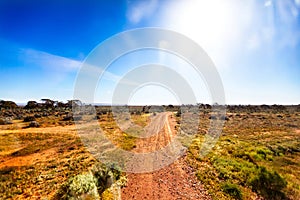 Gravel road in Australian outback in bright sunshine