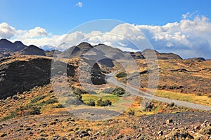 The gravel road curls among hills