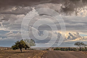 Gravel road en route to the Namibian desert with extremely dramatic sky, storm.