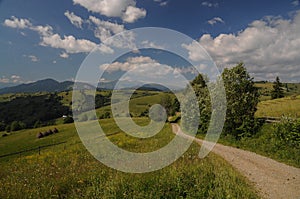 Gravel road in the green hills of Transylvania, Romania.