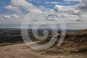 Gravel Road Leading Down into Arid Valley