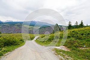 Gravel road in a mountain valley at the top of the Altai Mountains Summer