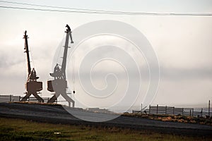 Gravel road near dockside cargo cranes at Pevek town