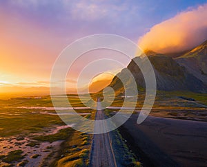 Gravel road at sunset with Vestrahorn mountain in the background, Iceland