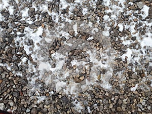Gravel road texture covered with snow winter time. Pebble pattern.  Fros morning. Snowy