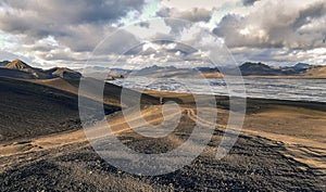 Gravel road to a braided glacial river and mountain range in Iceland`s remote Highlands, Sudurland, Iceland