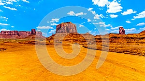 The gravel road winding past the towering red sandstone formations of Merrick and Mitten Buttes in Monument Valley