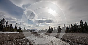 Gravel streambed under lenticular clouds in the springtime in Denali National Park in Alaska USA