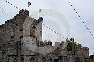 Gravensteen or Castle of the Counts, famous medieval monument in Ghent, Belgium, with flags of Ghent, Flanders and Belgium on