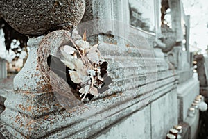 Gravestone in cemetery with flowers for concept of death and loss. All soul`s day