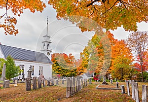 Gravestones of Hampshire cemetery with chapel and colorful trees at autumn season