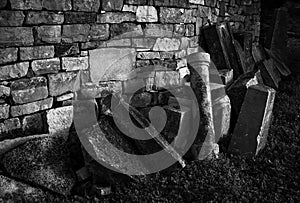 Gravestones lit by sun placed near a wall