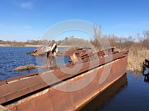 Graveyard of ships on the river. Many rusty barges and boats in water