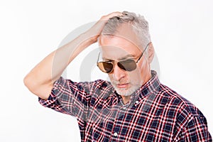 Gray aged man with sunglasses touching his hair