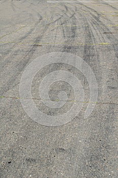 Gray asphalt with black tire tracks. An old country road with cr