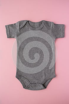Gray baby bodysuit mock up on a pink background - blank for own design