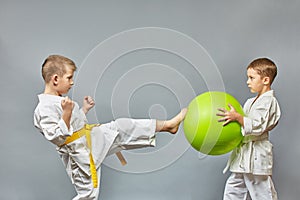 On a gray background, the athlete is doing kicks the green ball