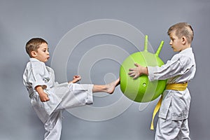 On a gray background, the boy kicks a kick on a green ball