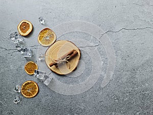 Gray background decorated with dried orange slices, coffee beans in gunny sack, cinnamon sticks on pine wood chip